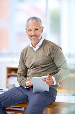 Buy stock photo A portrait of a happy businessman sitting on his desk with a tablet