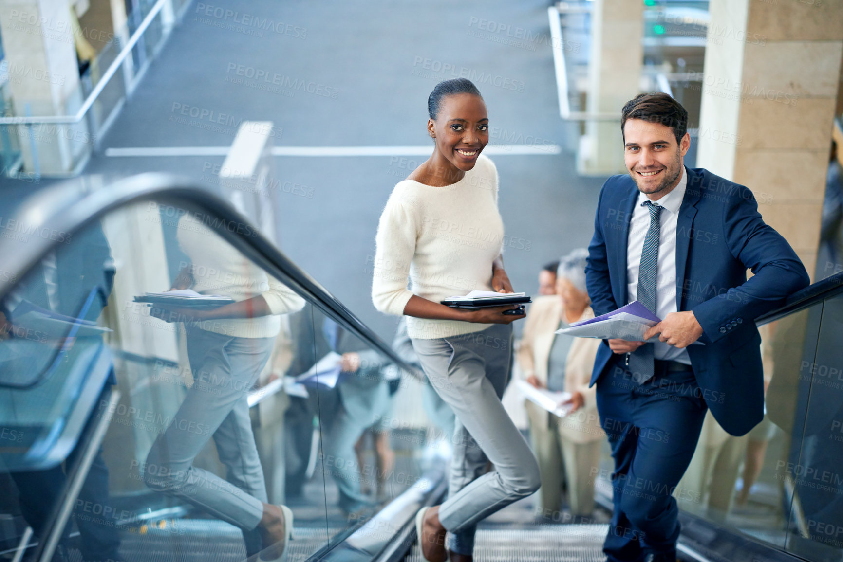 Buy stock photo Portrait of a young businesswoman and her male colleague on the escalator