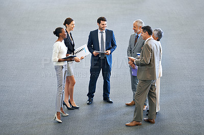 Buy stock photo High angle shot of a group of businesspeople talking in a lobby