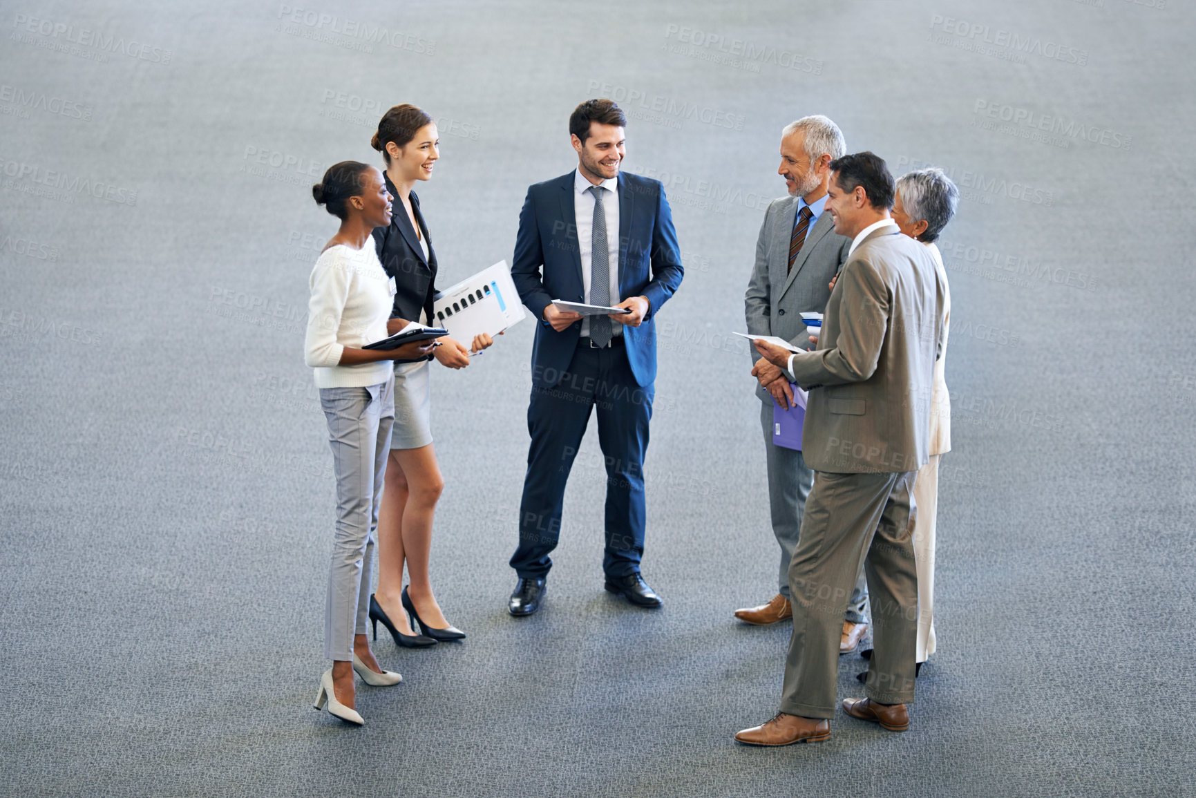 Buy stock photo High angle shot of a group of businesspeople talking in a lobby