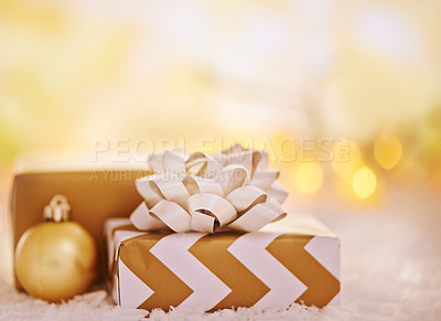 Buy stock photo Shot of golden presents and christmas ornaments on snow