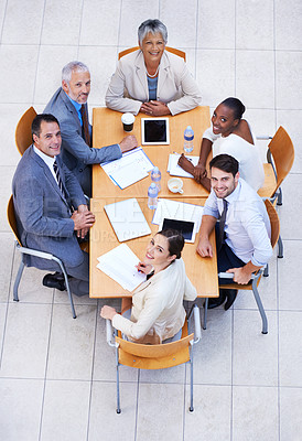 Buy stock photo High angle view of a group of businesspeople having a meeting at a conference table
