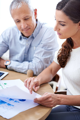 Buy stock photo Meeting, man and woman in office with documents for sales review, growth or development online. Planning, strategy and business people at desk with stats for data analysis, feedback or profit report