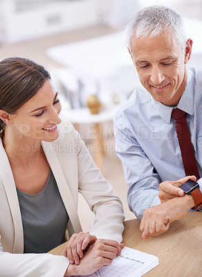 Buy stock photo Business people, colleagues and smart watch in office with future technology, screen or online. Mature, male person and woman with smile at finance agency or time management, teamwork or corporate