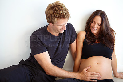Buy stock photo Pregnant, touching stomach and couple on a white background for love, care and support in studio. Future family, pregnancy and happy man and woman excited for bonding relationship, baby or parenthood