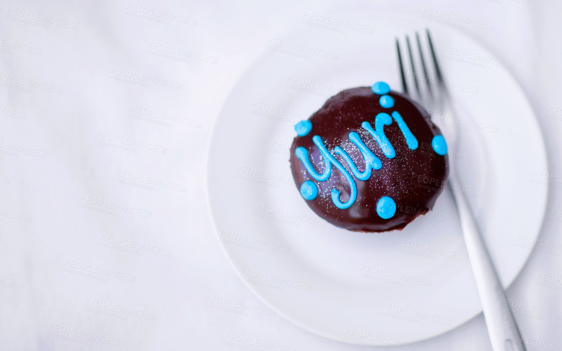 Buy stock photo Cupcake, chocolate cake and dessert on a plate for a birthday celebration with a name or work. Food, unhealthy eating and bakery sugar product on a table to celebrate at a party for Yuri from above