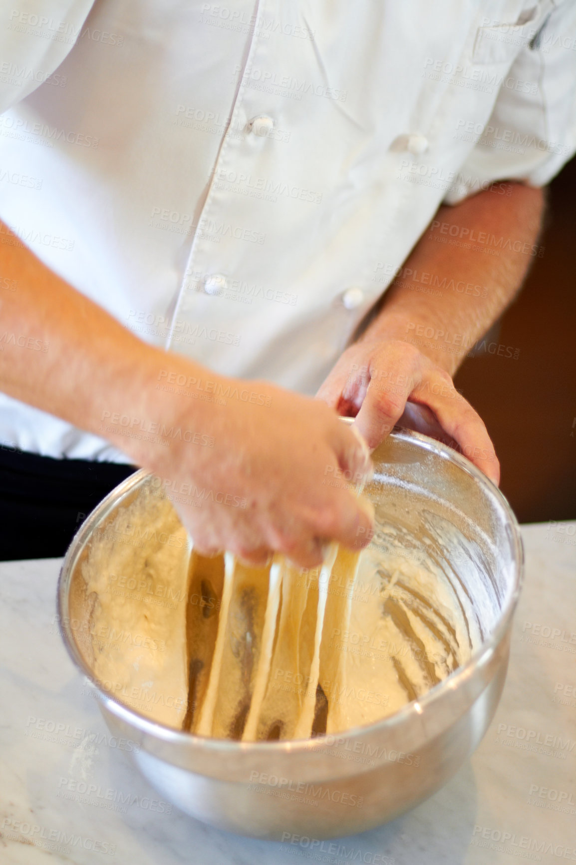 Buy stock photo Shot of a baker kneading dough in a bowl