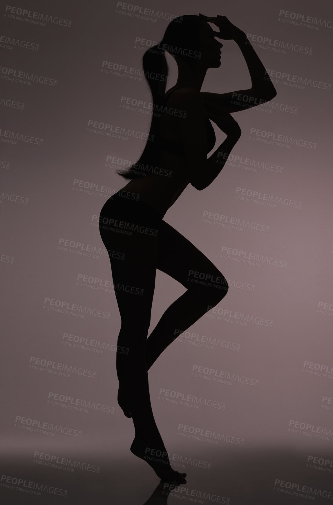 Buy stock photo Studio silhouette of a beautiful woman in lingerie against a gray background