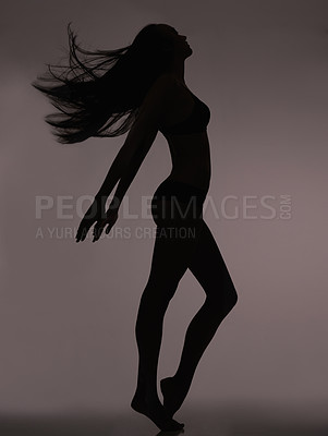 Buy stock photo Dancer, woman and silhouette with shadow figure, body care and sensual on a dark studio background. Person, profile and model with beauty and seductive with wellness and natural pose with slim girl