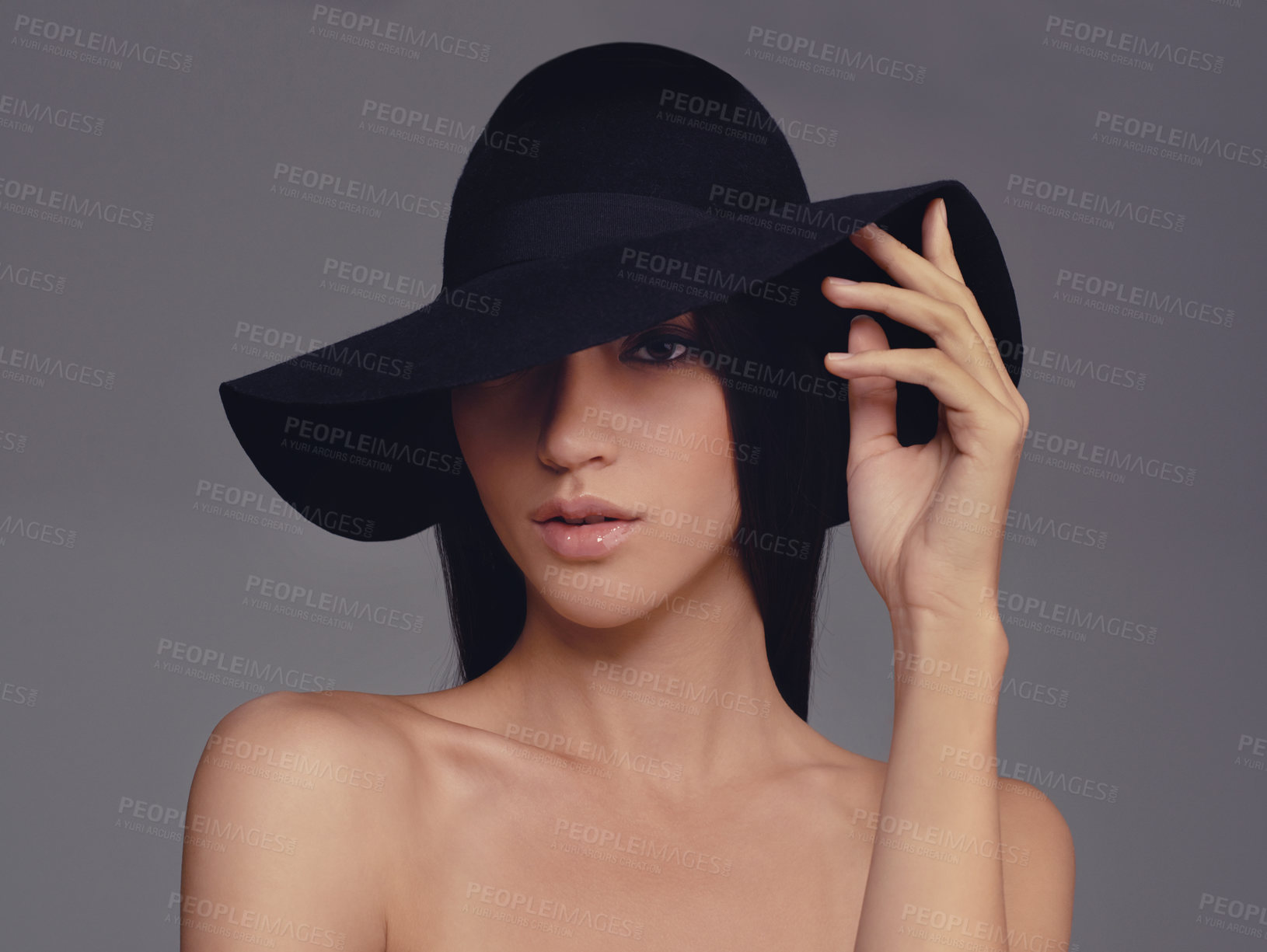 Buy stock photo Studio shot of a beautiful woman wearing a hat against a gray background