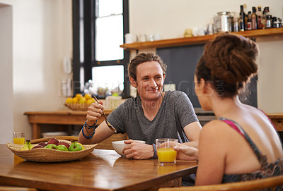 Buy stock photo Shot of  a happy couple with dreadlocks sitting down to breakfast