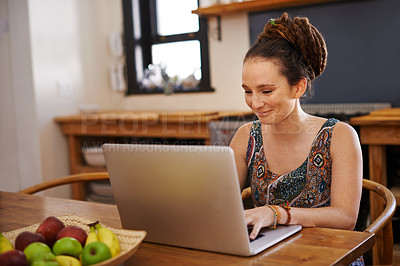 Buy stock photo Shot of a young woman with dreadlocks using a laptop at home