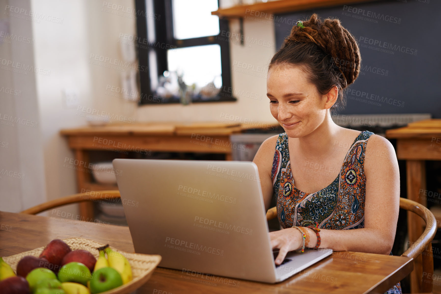 Buy stock photo Shot of a young woman with dreadlocks using a laptop at home