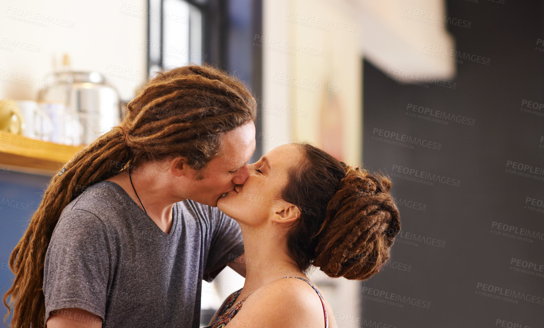 Buy stock photo Kitchen, kiss and couple in home for love, bonding relationship and commitment together. Dating, happy and Rasta man and woman embrace for affection in house for marriage, romance and happiness