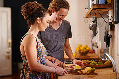 Buy stock photo Home, happy couple and cutting orange in kitchen for healthy diet, nutrition or wellness. Man, woman and chopping board with fruit at table for meal prep or food for organic breakfast in rasta house