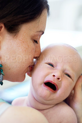 Buy stock photo Kiss, care and a mother with a crying baby for love, bonding and nurture in the bedroom of a house. Sad, fear and a mom with affection for a newborn or tired kid with emotion, frustrted or fatigue