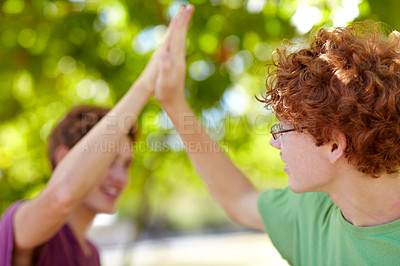 Buy stock photo Cropped shot of two teenagers giving each other a high-five