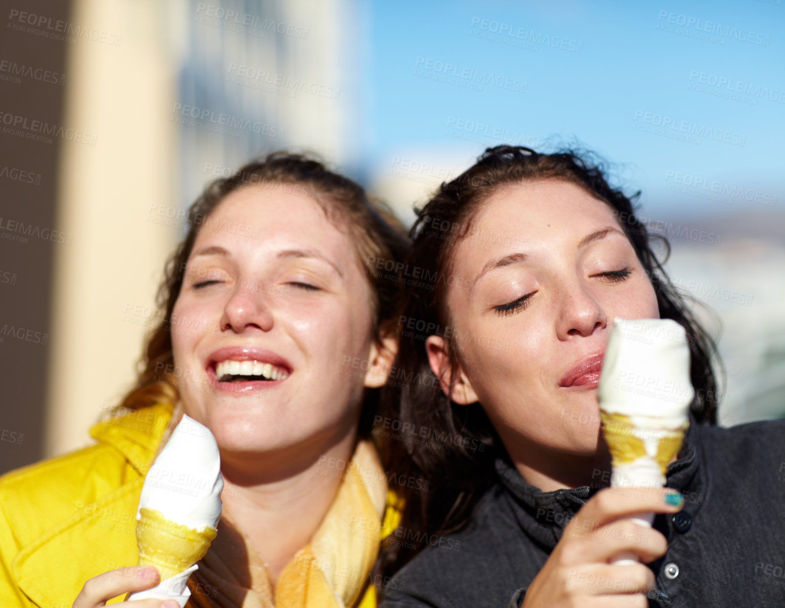 Buy stock photo Shot of two teenage sisters having ice-cream outside