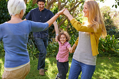 Buy stock photo Shot of a happy multi-generational family playing outside in the garden