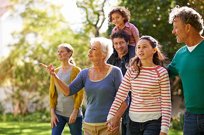 Buy stock photo Shot of a family walking together outside in the garden