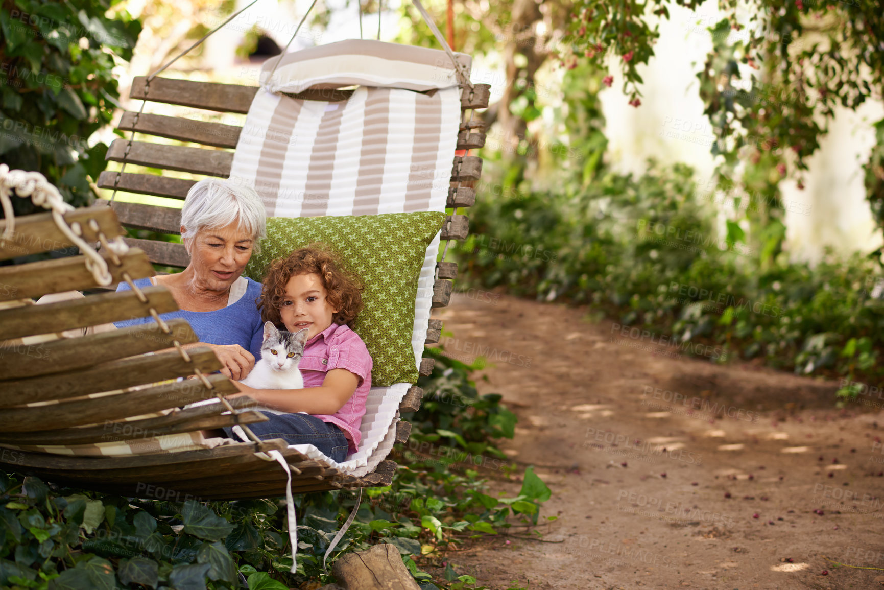 Buy stock photo Grandmother, child and relax on outdoor hammock, garden and cat or pet care for love on weekend. Senior woman, girl and animal for conversation in nature or backyard, bonding and affection