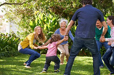Buy stock photo Shot of a multi-generational family playing together in the garden
