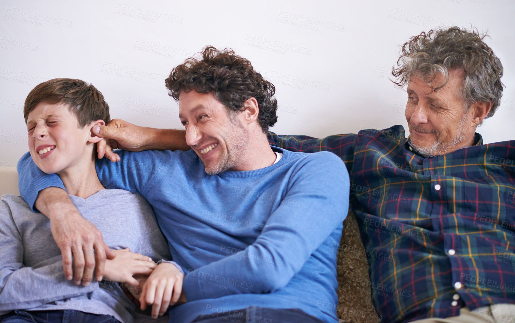 Buy stock photo Happy, playing and boy with father and grandfather on sofa in living room for funny, comic or comedy. Smile, laughing and young child bonding with dad and senior man for fun together at home.