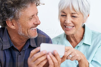 Buy stock photo Smile, phone and mature couple networking internet, mobile app or website together for bonding. Happy, love and senior man and woman reading online blog for information with cellphone for marriage.