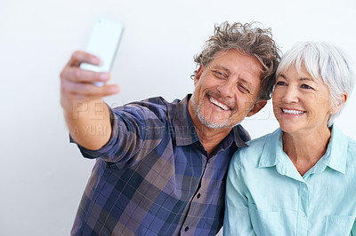 Buy stock photo Old couple, selfie and happy together for social media post, memory and love with joy on white background. Trust, support and loyalty with people in marriage, smile in picture for post and mobile app