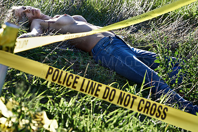 Buy stock photo Shot of a murdered woman's corpse cordoned off with police tape