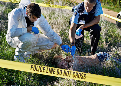 Buy stock photo Shot of investigators collecting forensic evidence from a crime scene