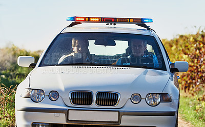 Buy stock photo Policeman, car and drive in field to search at crime scene or robbery, safety and law enforcement for evidence. Detective, investigation and uniform in outdoor working at countryside with gravel road