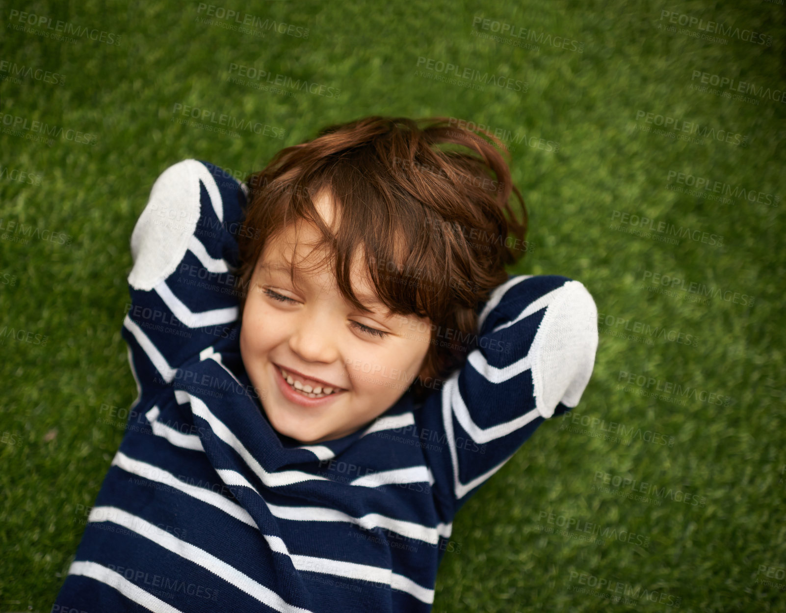 Buy stock photo Child, relax and happy on green grass for holiday, vacation and outdoor wellness in nature. High angle or above of a young kid, boy or student on lawn with excited face for playground, park or spring