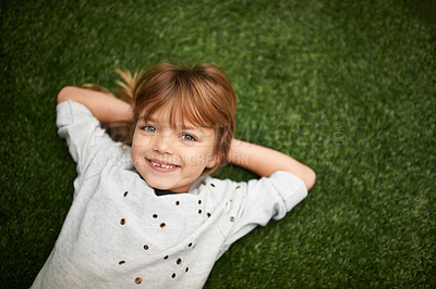 Buy stock photo Little girl lying on the grass with her hands behind her head