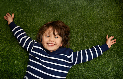 Buy stock photo Happy, above and portrait of child on grass for relax, playful fun and happiness in garden. Family, nature and young boy for childhood, playing and freedom on weekend, vacation or holiday outdoors 