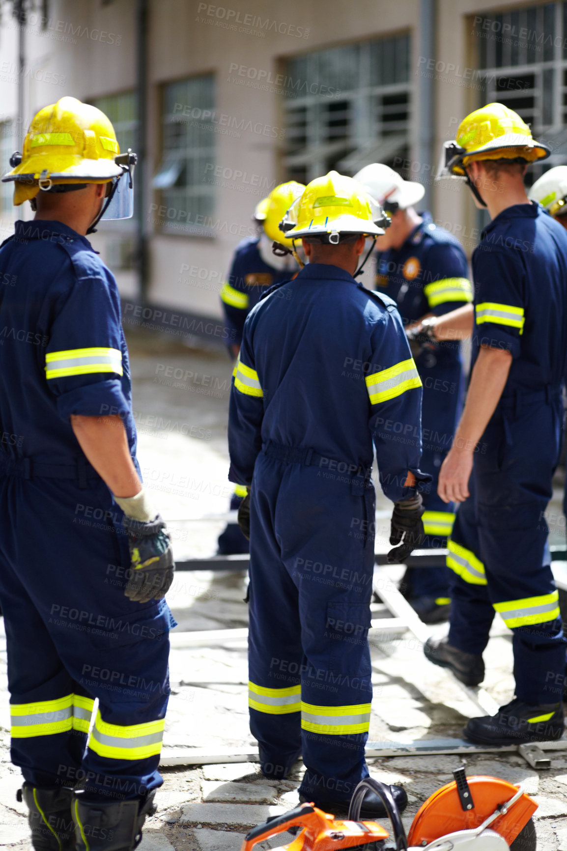 Buy stock photo Shot of a group of firemen standing outside a fire station