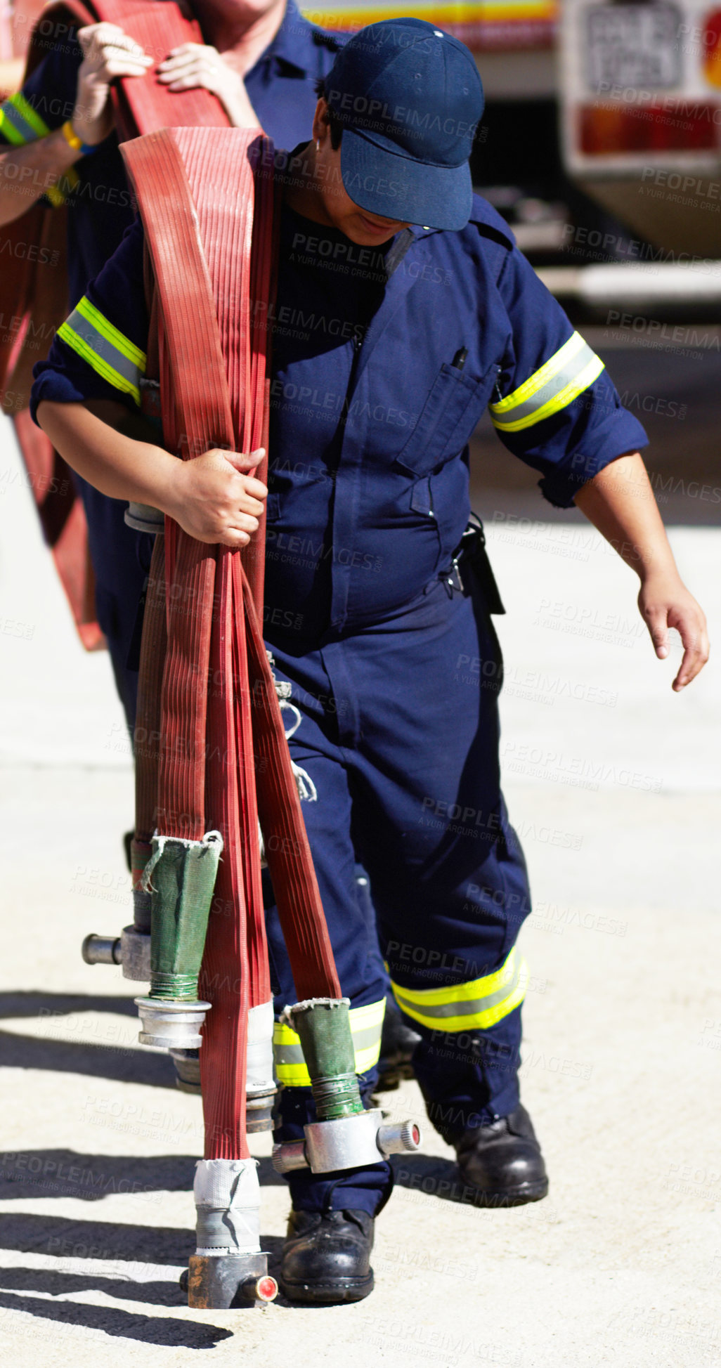 Buy stock photo Firefighter, team and carrying hoses for emergency, rescue or fire drill from truck outdoors. Firefighters working together in practice lifting big liquid pressure pipes outside station or department