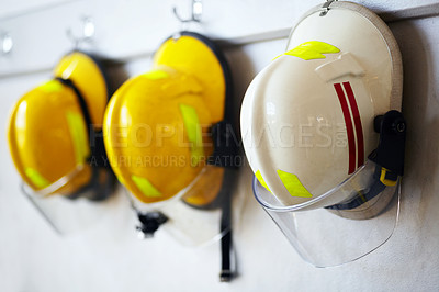 Buy stock photo Shot of firemen's helmets hanging from a wall