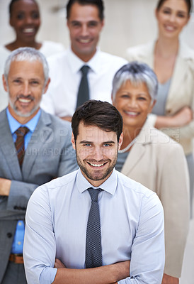 Buy stock photo Portrait of a smiling businessman surrounded by a group of his colleagues