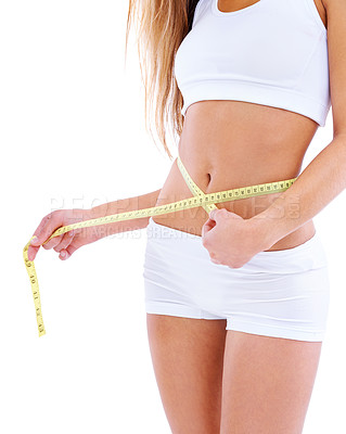 Buy stock photo Cropped studio shot of a woman measuring her waistline isolated on white