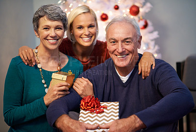 Buy stock photo Shot of a small family exchanging gifts at christmas