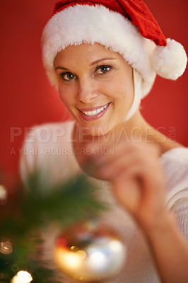Buy stock photo Woman, portrait and Christmas tree for holiday decoration, celebration and happy for tradition on a red or wall background. Face of a person in cap with bulb or ornament for thanksgiving at home