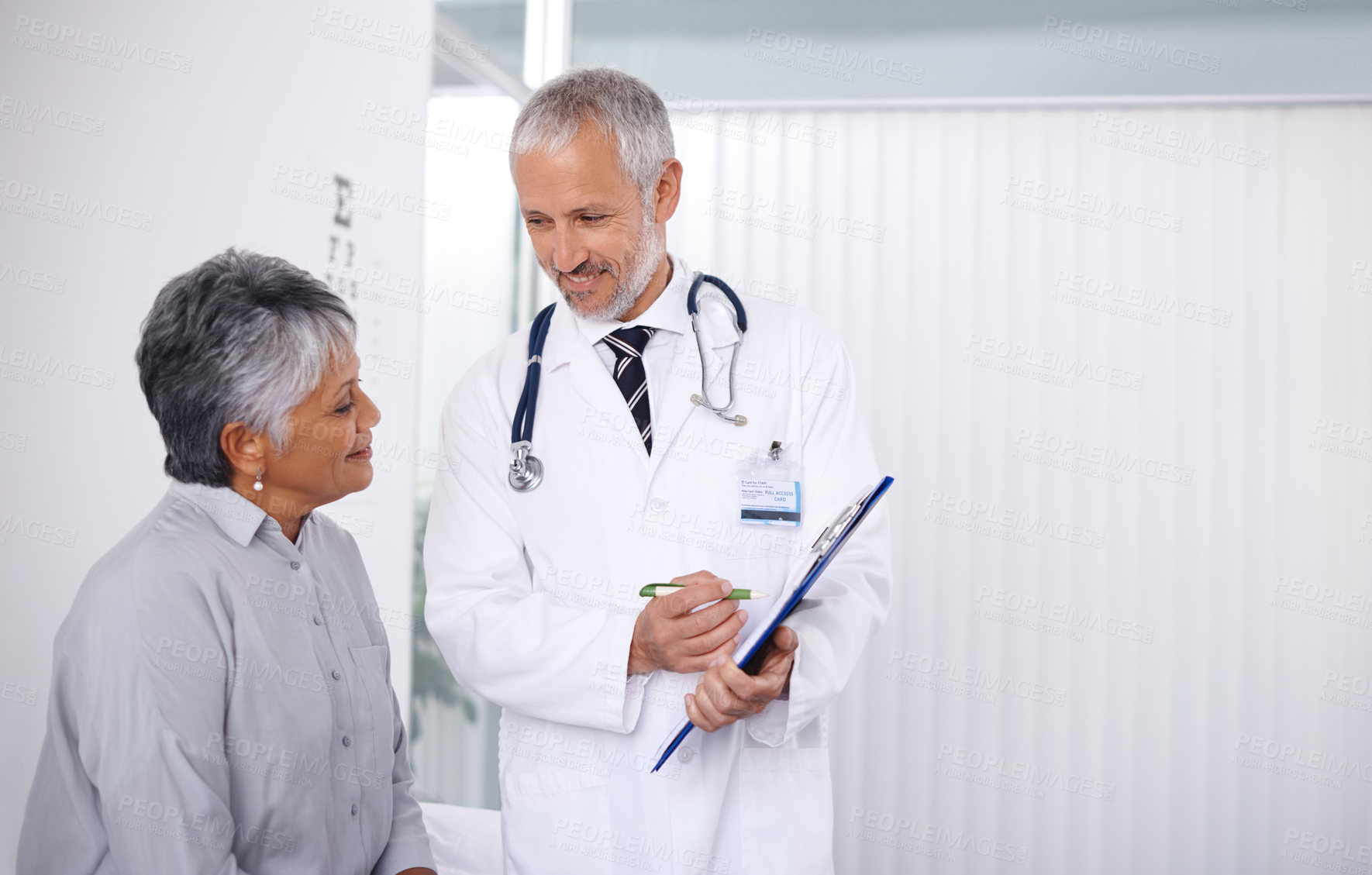 Buy stock photo A happy doctor seeing to one of his mature patients
