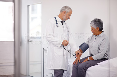 Buy stock photo A doctor measuring a mature patient's blood pressure