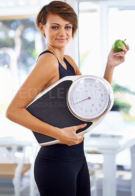 Buy stock photo A beautiful young woman standing holding a scale