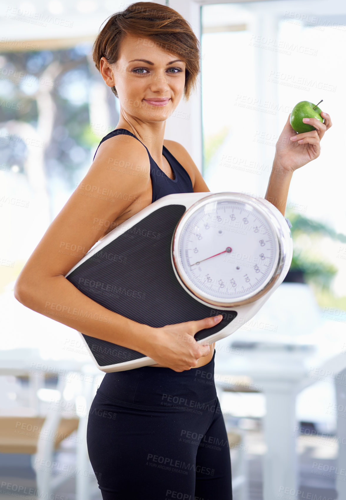 Buy stock photo A beautiful young woman standing holding a scale