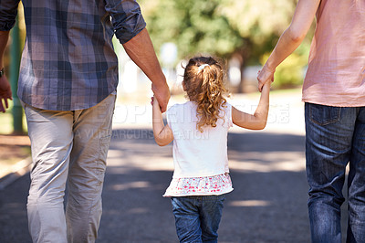 Buy stock photo Rear view shot of a young family walking down the street
