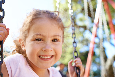 Buy stock photo Girl, child and portrait on swing for playing in park with happiness, wellness and outdoor in South Africa. Kid, face and smile on playground for recreation, healthy childhood development and freedom