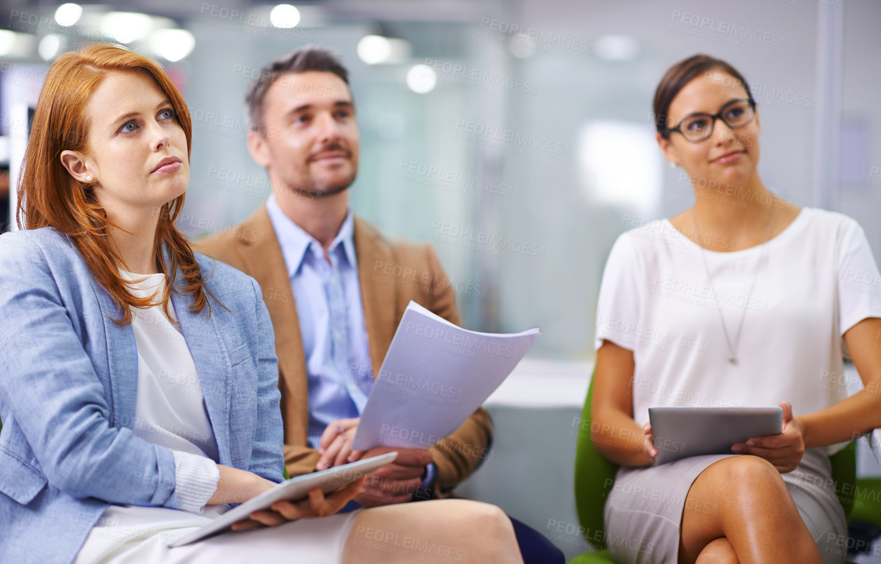 Buy stock photo Shot of three colleagues listening to a presentation