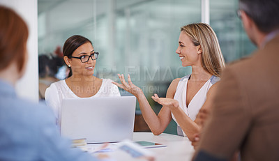 Buy stock photo Shot of two female colleagues discussing ideas